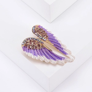 Detailed macro view of purple angel wing brooch with crystals and gold-tone alloy edges