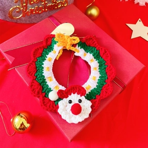 Detail of knitted pet Christmas collar with Santa Claus charm on a red festive gift box