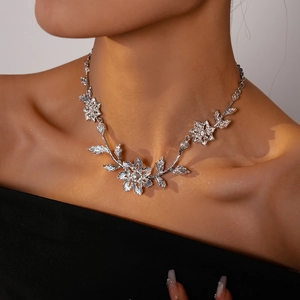 Detail of silver floral clavicle necklace with pavé zircons on model neck