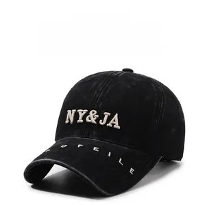 Detailed macro view of 3D NY&JA embroidery on washed black vintage baseball cap