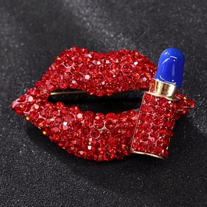 Macro shot of red rhinestone lip and blue enamel lipstick brooch with gold plating