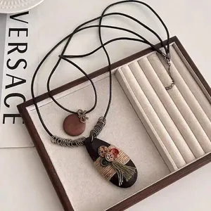 Retro ethnic long necklace with wooden pendants and tassels in a jewelry box