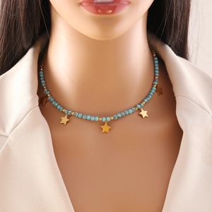 Bohemian turquoise bead necklace with golden star pendants worn by a professional model