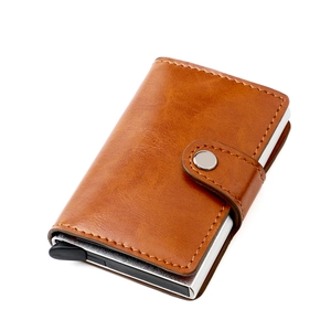 Detail view of caramel RFID blocking card holder with metal slot and leather texture