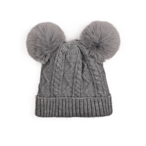 Détail du bonnet en maille grise avec deux pompons en fausse fourrure et bord côtelé