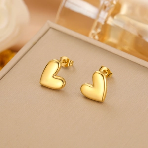 Detailed view of polished heart-shaped gold earrings on a premium display box