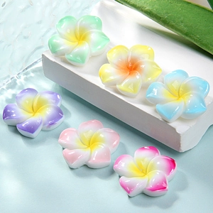 Detail view of colorful resin frangipani flower accessories for DIY crafts and hair clips