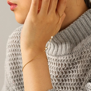 Detailed close-up of a gold chain hand harness featuring a round zircon on a model hand