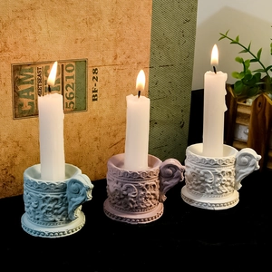 Detalle de candelabros vintage con relieves de estilo europeo y asa para transporte