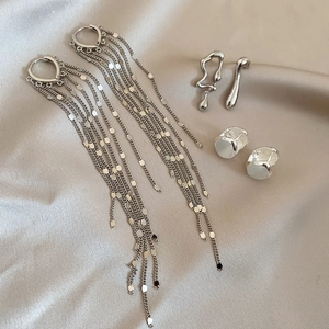 Detailed view of silver tassel earrings with liquid metal and white pearl studs set