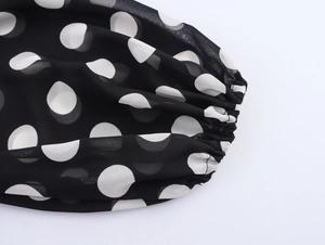 Detail of elastic cuffs and white polka dot pattern on black chiffon dress fabric