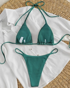 Detail of emerald green ribbed bikini fabric texture with adjustable halter ties