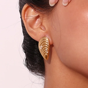 Gros plan détaillé de boucles d'oreilles dorées texturées coquillage avec perles