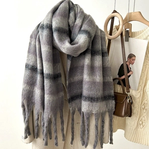 Thick mohair-style plaid scarf in grey-purple with long tassels on a wooden hanger