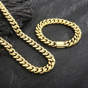 Hip hop style gold Cuban chain set featuring a necklace and bracelet on dark background