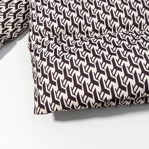Close-up of geometric black and white printed padded jacket showing quilted texture