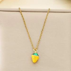 Detailed close-up of a gold strawberry pendant with yellow oil dripping and white dots