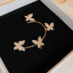Macro shot of gold butterfly ear cuff featuring four sparkling rhinestone encrusted wings