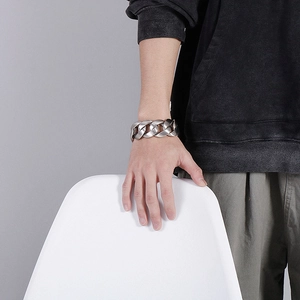 Close-up of thick silver titanium steel Cuban link bracelet on a male model wrist