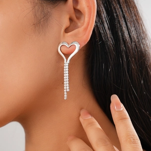 Close-up of a zircon hollow heart tassel earring worn by a model to show elegant shine