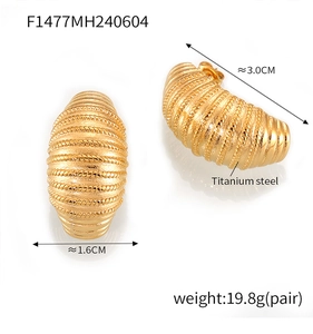 Macro detail of gold titanium steel C-hoop earrings featuring spiral cocoon texture