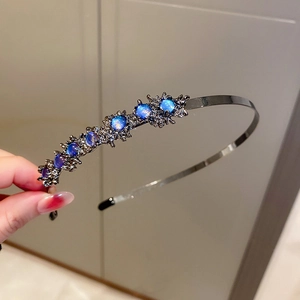 Detailed view of luxury blue rhinestone headband with metallic base and intricate crystals