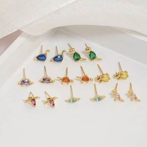 Detail of colorful dinosaur stud earrings set with 18K gold base and zircon stones