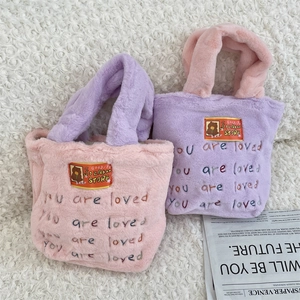 Détail du sac cabas en peluche montrant la texture douce et la broderie colorée