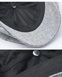 Close-up of grey linen newsboy cap showing reinforced stitching and black inner lining