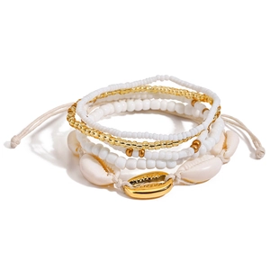 Detail of multilayer anklet with white beads and natural shells on a clean background