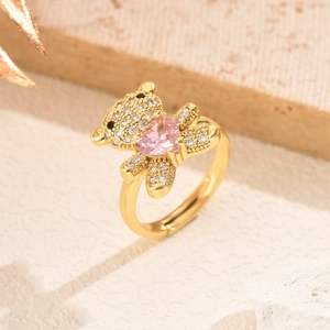 Close-up of golden bear ring with micro-pave zircons holding a pink heart gemstone