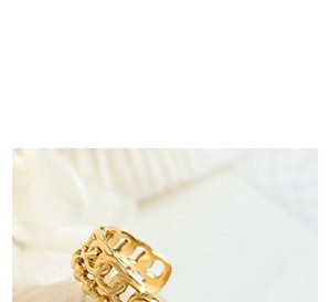 Close-up of golden hollowed chain link jewelry on a soft white fabric background