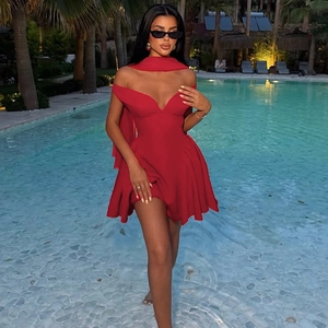 Detail of red off-shoulder mini dress with matching long scarf by a pool setting