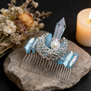 Detail of silver moon hair comb with blue crystals and white pearl on natural stone