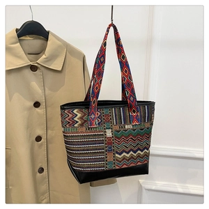 Detailed view of colorful woven ethnic pattern and black leather trim on canvas tote bag