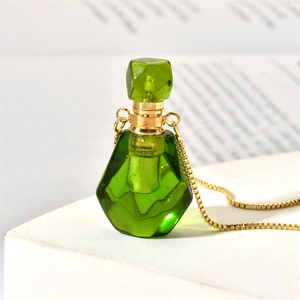 Detail of green multifaceted glass perfume bottle pendant on a delicate gold chain