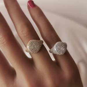 Macro close-up of sparkling micro-pave gold and silver rings worn on a hand