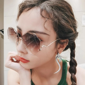 Fashionable rimless gradient brown sunglasses with wavy gold temples on female model