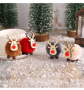 Detailed view of four colorful felt and wood reindeer ornaments on artificial snow