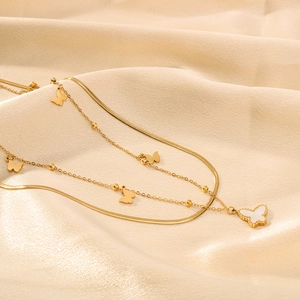 Double-layered butterfly necklace with white shell pendant on champagne satin fabric