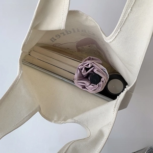 Detailed interior view showing large capacity for laptop, books and umbrella in tote bag