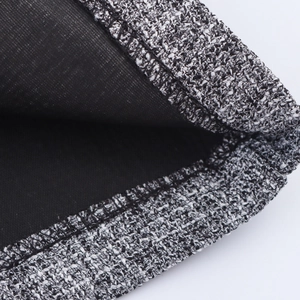 Women's two-piece tweed suit showing textured black and white fabric with black lining