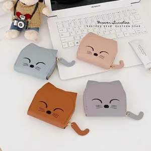 Cute cat-shaped PU leather wallets with embroidery in four pastel colors on a desk