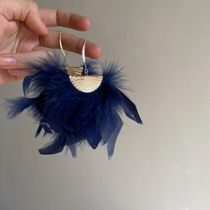Detail of gold hammered metal finish and deep blue feather fringe on these ethnic earrings