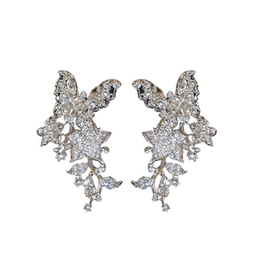 Silver butterfly earrings with zircon tassels and floral accents on a white background