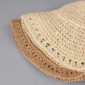 Handwoven straw sun hat with detailed hollow pattern and wide brim in cream and tan colors