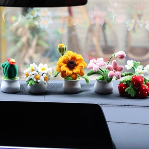 Row of colorful handmade crochet sunflower and cactus car dashboard potted plants