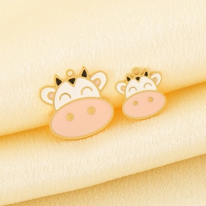 Golden stainless steel cartoon cow pendants with colorful enamel on satin background
