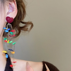 Detail of colorful bohemian heart fringe earrings with multi-color beads on model