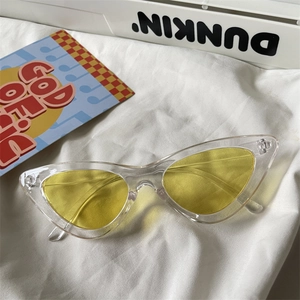 Macro detail of cat-eye sunglasses with transparent frames and yellow tinted lenses